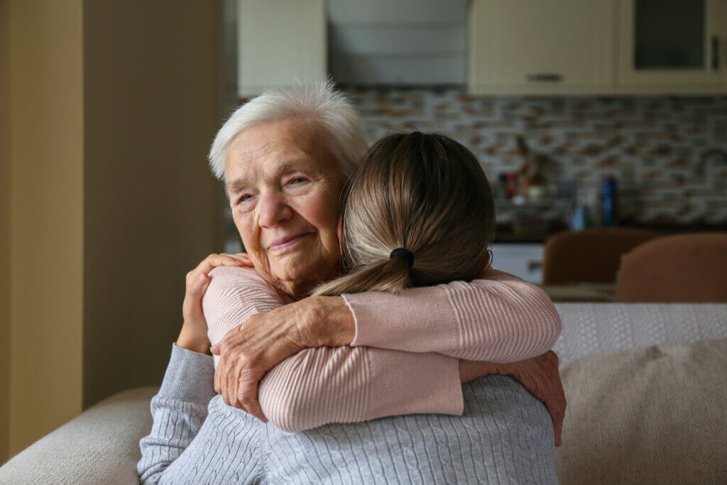 A young woman hugging her elderly relative