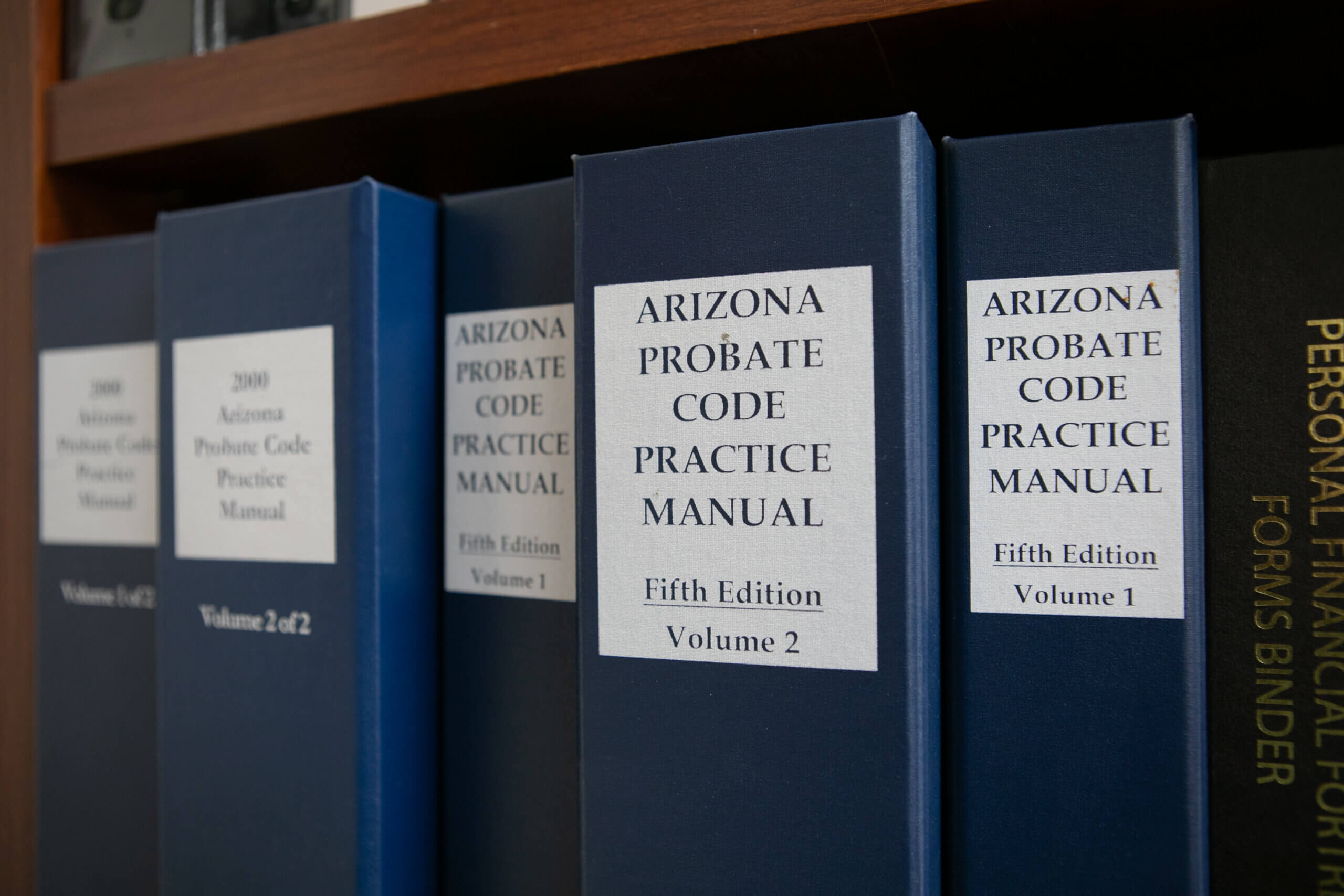 Blue Binders lining a shelf containing information needed to provide paralegal services in Arizona