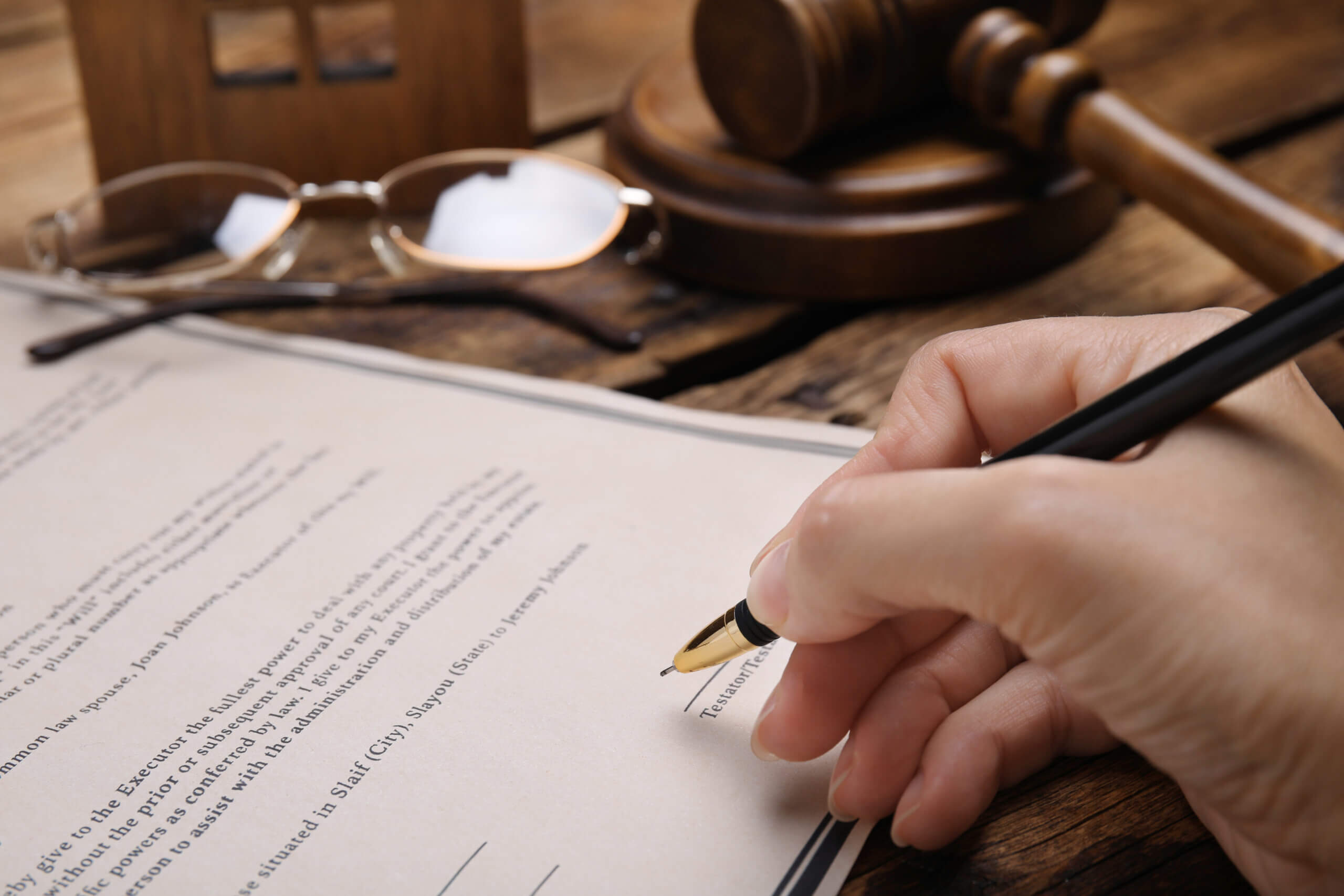 A woman signing legal documents prepared using the probate services at AZ Statewide Paralegal